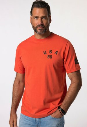Orange cotton t-shirt with short sleeves, featuring "USA 80" printed in black on the chest and a logo on the sleeve. Casual fit.