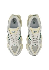 Graue und cremefarbene Sneakers aus Mesh- und Leder-Materialien. Mit grünen Akzenten, Schnürung und gepolsterter Zunge für zusätzlichen Komfort.