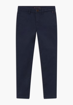 Marineblå slim-fit chinos med knaplukning, bæltestropper, forlommer og et lille Tommy Hilfiger flaglogo nær højre lomme.