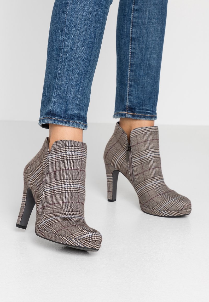 Bottines à carreaux marron avec talons hauts, présentant une texture lisse, un design à bout pointu et un détail de fermeture éclair latérale.