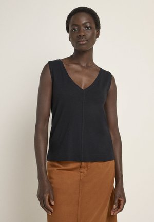 Black sleeveless top with a V-neck design, featuring a relaxed fit and subtle stitching details. Paired with a brown skirt.
