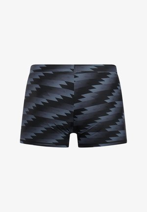 Zwembroek in een zwart-grijs zigzagpatroon, gemaakt van rekbare stof, met een nauwsluitend ontwerp en een gladde textuur.