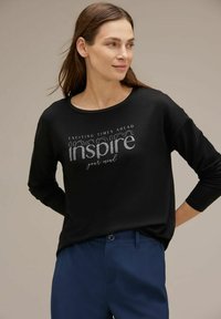 Maglietta nera a maniche lunghe con testo metallico argento "ispira la tua mente" e "Tempi emozionanti in arrivo". Tessuto morbido con una vestibilità comoda.