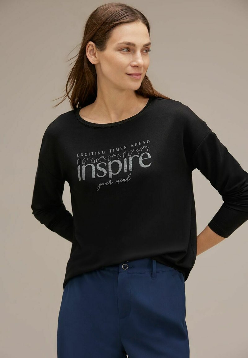 Maglietta nera a maniche lunghe con testo metallico argento "ispira la tua mente" e "Tempi emozionanti in arrivo". Tessuto morbido con una vestibilità comoda.