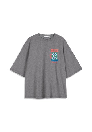 T-shirt gris à manches courtes avec texte coloré "Monster Tea Club" et motif abstrait de tasse de thé sur la poitrine.