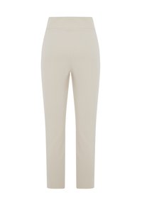Beige stretchbyxor med en slät, sömlös midja, tapered ben design och inga synliga sömmar, som har en ren och minimal look.