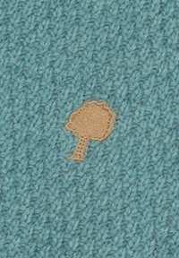 Blau gestrickter Stoff mit einer kleinen, hellbraunen Baumform, die in der Mitte eingenäht ist.