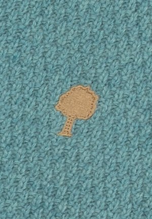 Knitted blue fabric with a small, light brown tree shape stitched in the center.