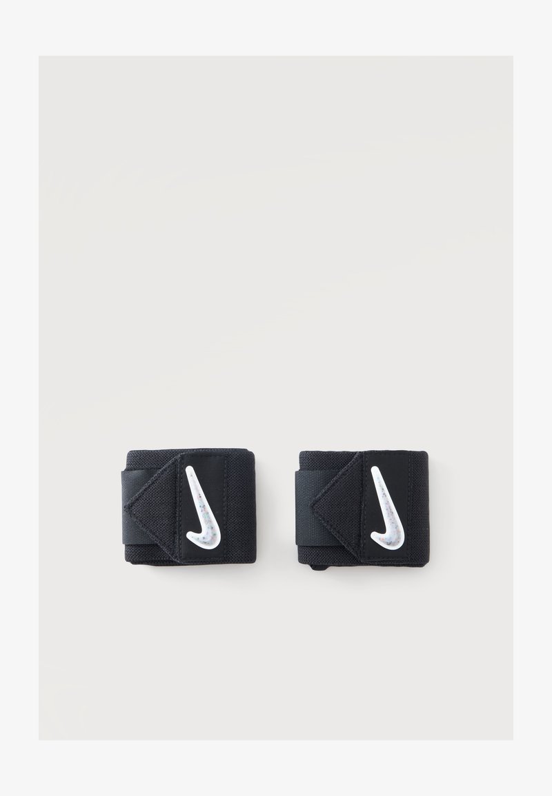 Ζευγάρι μαύρα περιτυλίγματα καρπού Nike με λευκά λογότυπα swoosh σε απλό φωτεινό φόντο.