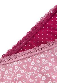 Tela con encaje que presenta patrones florales y de lunares en tonos de burdeos y rosa, combinados en un diseño en capas.