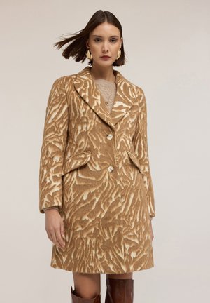 Cappotto marrone e crema con un motivo, dalla vestibilità aderente, maniche lunghe e due bottoni. Presenta un colletto a punte e tasche frontali. Texture morbida.