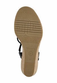 Sole di sandal nero con gomma marrone texture, caratterizzata da un tacco in sughero. Le marcature includono "Tamaris" e la taglia "37" sulla base.
