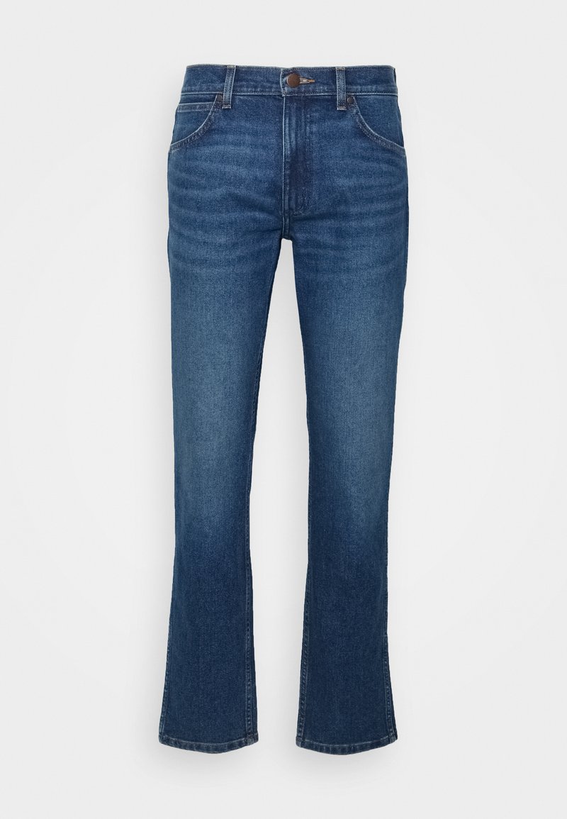 Jeans de campana de mezclilla en azul oscuro. Presentan un diseño de cinco bolsillos, costuras visibles, cierre de botón metálico y un ligero desgaste en la parte delantera.