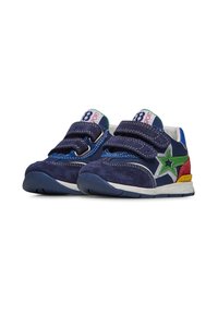 Námořnické modré semišové tenisky s akcentem zelené hvězdy, bílými pruhy a červenými, žlutými a modrými detaily. Obsahují double Velcro popruhy pro zapínání.