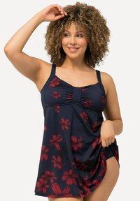 Robe de bain marine avec un motif floral rouge, bretelles ajustables et détail de buste froncé. Tissu fluide avec une coupe décontractée et fente sur le côté.