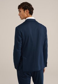 Giacca da completi in blu navy con texture, colletto a rever, spacco singolo e dettagli in bottone. Presenta una vestibilità su misura e un tessuto liscio.