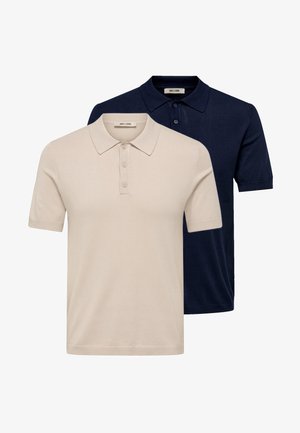 Twee korte mouw polo's, één beige en één marineblauw, met knoopsluitingen en kraag, gestapeld met een beige overhemd voorop.