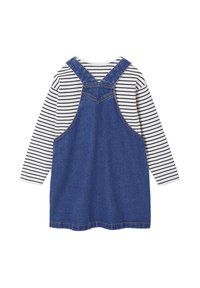 Blaue Jeanslatzhose mit verstellbaren Trägern, kombiniert mit einem weißen und marineblauen gestreiften Langarmshirt darunter. Aus einem Baumwoll-Mix.