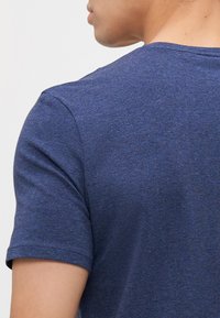 Námořnická modrá trička s krátkým rukávem vyrobená z texturované tkaniny, s kulatým výstřihem a bezšvovými rameny, s jemnými melírovými vzory.