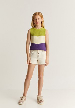 Top de crochet sin mangas con rayas verdes, blancas y moradas; combinado con pantalones cortos de denim blancos con dobladillo deshilachado y cierre de cinco botones.