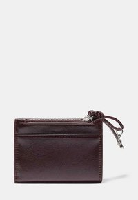 Portfel z bordowej skóry o gładkiej fakturze, wyposażony w komorę na suwak i zewnętrzną kieszeń, wykończony srebrnym suwakiem.