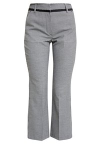 Rutiga byxor i svart och vitt med en åtsittande design, slät front och en subtil accent vid midjan. Tillverkade av ett mjukt tyg.