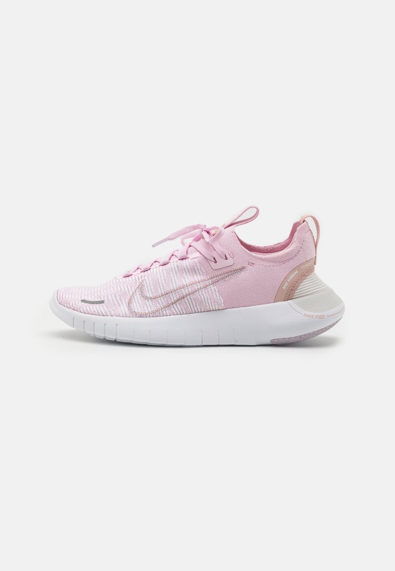 Chaussure de running Nike rose clair avec semelle blanche, empeigne en maille, languettes sur la languette et le talon, et swoosh Nike visible sur le côté.