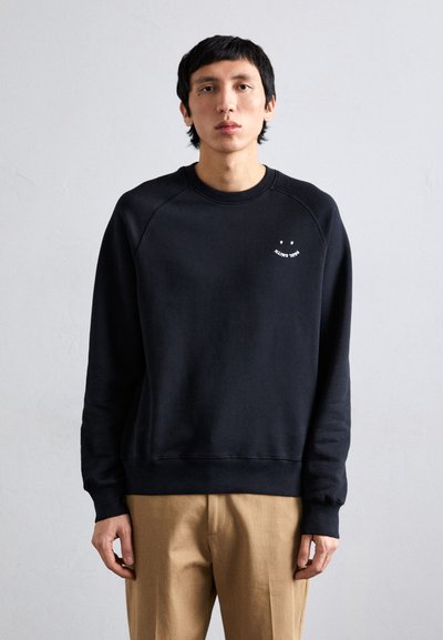 Zwarte sweatshirt met een ronde hals en lange mouwen, voorzien van een kleine witte graphic op de borst. De stof lijkt zacht met een gladde textuur.