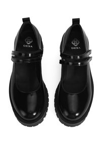 Schwarze Lacklederschuhe mit einer abgerundeten Zehenpartie, zwei glänzenden Riemen und einer dicken schwarzen Gummisohle. Das Logo "DESA" ist auf der Innensohle sichtbar.