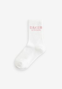 Calzino bianco in cotone con texture a coste, con la scritta rosa "BAKER" e "by TED BAKER" di lato. Design classico alla caviglia.