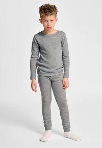 Graues thermisches Langarmoberteil und Leggings aus weichem, elastischem Material, mit Rundhalsausschnitt und körpernahem Schnitt, kombiniert mit weißen Socken.