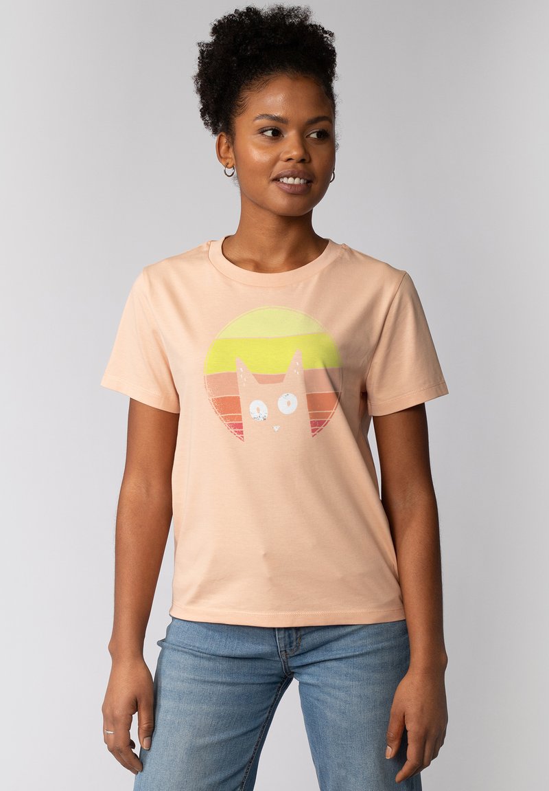 Perzikkleurig katoenen t-shirt met een ronde afbeelding van een kat en zonsondergangstrepen in geel, oranje en rood. Korte mouwen en ronde hals.