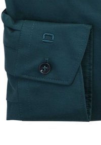 Ciemnozielona długa koszula z długim rękawem, mankiet z guzikiem, złożony fason i przeszycia. Gładka faktura z delikatnym połyskiem.