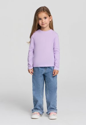 Fioletowa bluzka z długim rękawem w połączeniu z luźnymi, jasnoniebieskimi dżinsami. Białe sneakersy z różowymi akcentami. Prosty design, bez widocznych wzorów.