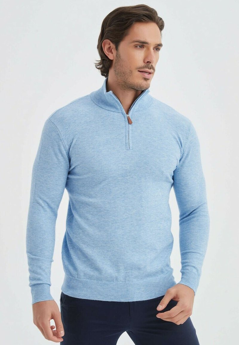 Pull bleu clair avec un zip quart, des poignets et un ourlet côtelés. Fabriqué en matériau doux avec un motif tricoté texturé.