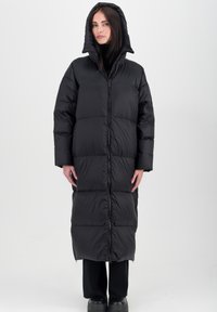 Longue doudoune noire avec fermeture éclair à l'avant, capuche et design matelassé. Fabriquée en matériau brillant et imperméable, avec une coupe ample et des manches longues.