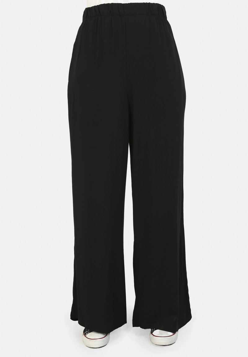 Pantaloni neri a gamba larga realizzati in tessuto morbido con vita elasticizzata, dotati di spacchi laterali all'orlo e una texture liscia.