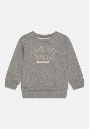 Sweat-shirt gris à manches longues avec poignets et ourlet côtelés, avec les inscriptions "LOOK OUT WORLD" et "I'M NEW IN TOWN" sur le devant.