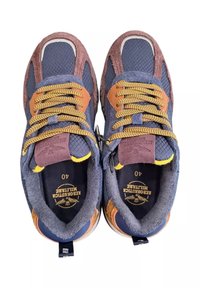 Un paio di scarpe sportive blu e marroni con lacci gialli, tessuto testurizzato e il nome del marchio "AERONAUTICA MILITARE" stampato all'interno.