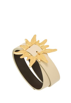 Béžový kožený opasek s velkou zlatou sponou ve tvaru slunce s čtvercovým středem a vyzařujícími paprsky.