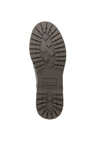 Bruine rubberen zool van de laars met een robuust profiel en kruisvormige noppen voor grip. "Travelin" logo nabij de hiel. Maat 39 is gemarkeerd.