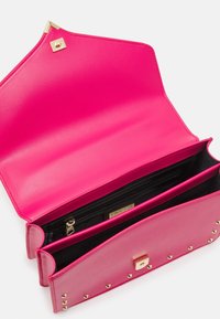 Bolso de mano de cuero rosa con herrajes dorados, cuenta con dos compartimentos, un bolsillo con cremallera y detalles con tachuelas en la parte frontal.