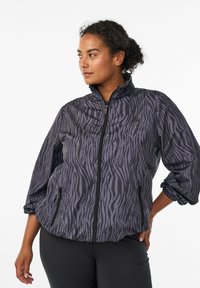 Leichte, schwarz-graue Zip-Jacke mit einem Zebra-Streifen-Muster, elastischen Bündchen und seitlichen Taschen. Glattes, leicht glänzendes Material.