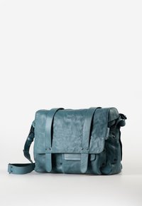 Blaugraue Leder-Umhängetasche mit vorderer Klappe, zwei Riemen, Seitentaschen und verstellbarem Schultergurt vor weißem Hintergrund.