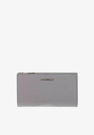 Portefeuille rectangulaire en cuir gris clair avec le logo "Coccinelle" en lettres dorées et une fermeture éclair sur le côté supérieur gauche.