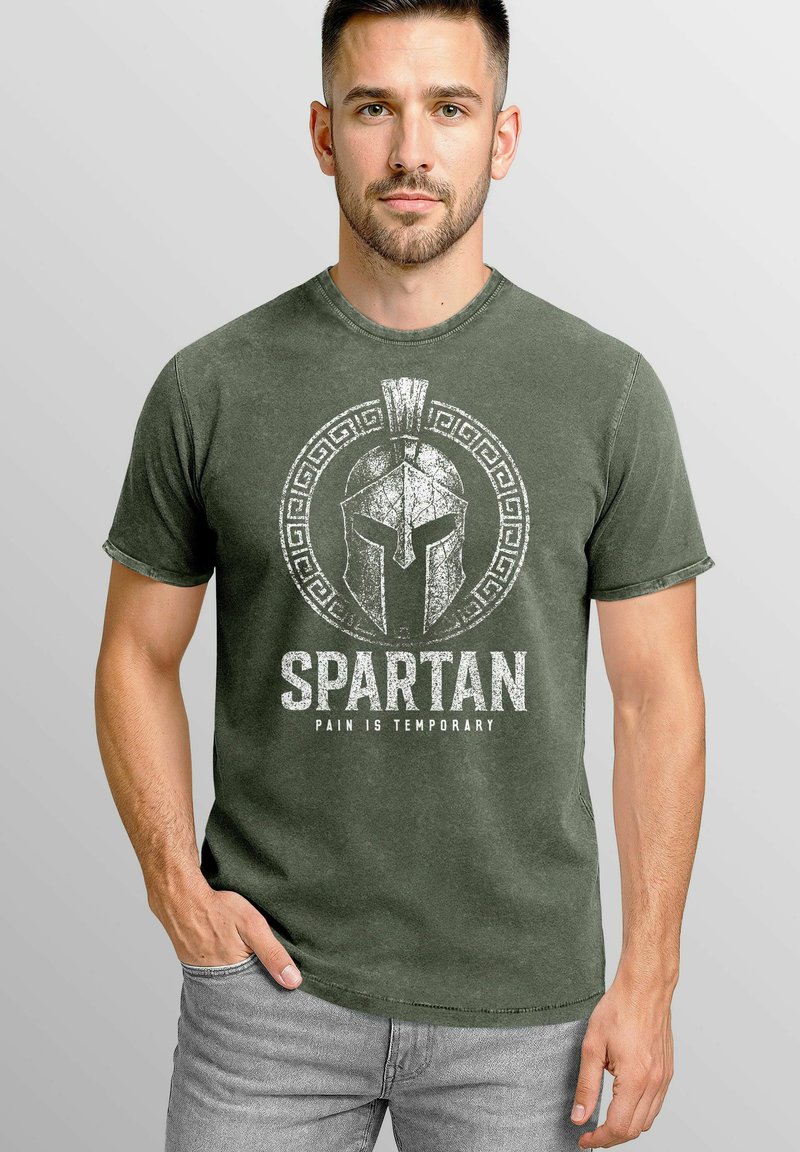 Olive green cotton t-shirt featuring a white Spartan helmet graphic with text "SPARTAN" and "PAIN IS TEMPORARY" in distressed font. Short sleeves.
