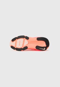 Shoe sole with a black rubber base, pink midsole, and textured surface; features tread patterns and a small accent logo.