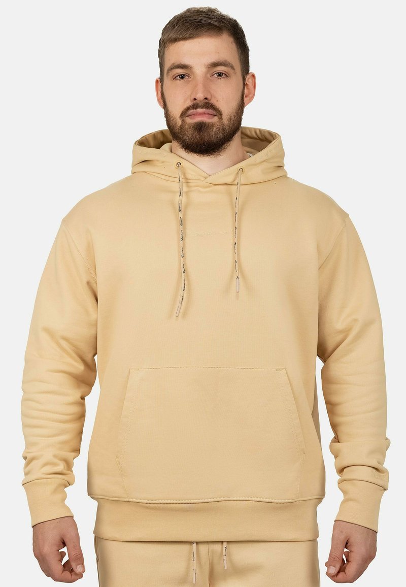 Felpa beige con cappuccio realizzata in tessuto morbido, caratterizzata da una tasca a marsupio, polsini a costine e dettagli con coulisse.
