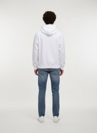 Vit hooded sweatshirt med en smidig yta, kombinerad med ljusblå jeans. Outfiten kompletteras med vita sneakers.