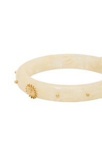 Bracelet en résine marbrée ivoire avec motif de soleil en or et petits clous dorés espacés uniformément autour du bandeau. Forme lisse et solide. Largeur : 1,5 cm.